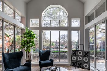 an arched window in a living room with two chairs and a coffee table